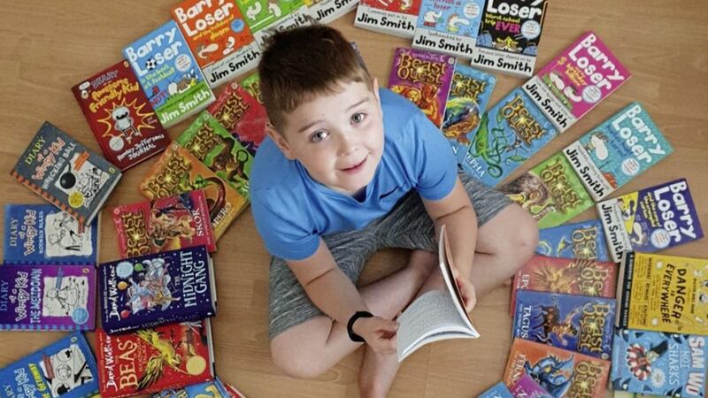 Josh Cullen from Derry, surrounded by some of the 70 books he read during lockdown 