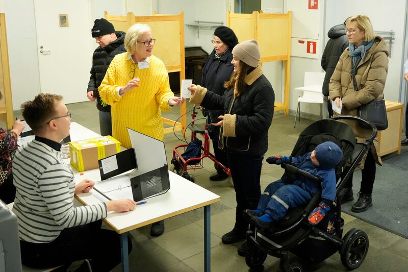 People queue to cast their votes at a polling station in Helsinki (Sergei Grits/AP)