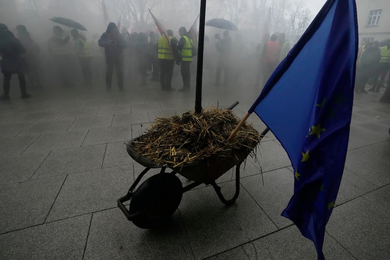 Polish farmers, angry at EU policy, park a wheelbarrow full of manure with the EU flag in it, in front of the office of the regional governor in Poznan, western Poland