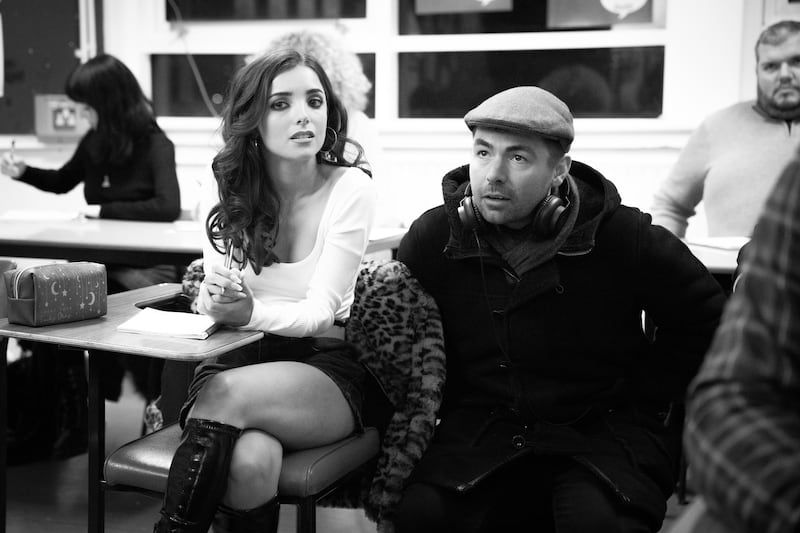 A black and white photo of Kneecap director Rich Peppiatt on the set with actor Jessica Reynolds