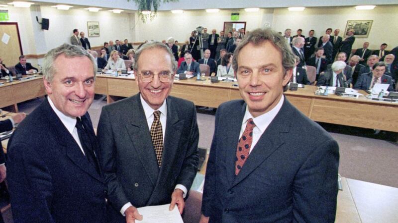 Tony Blair, Senator George Mitchell and Bertie Ahern smiling after they signed the Good Friday Agreement in 1998. 