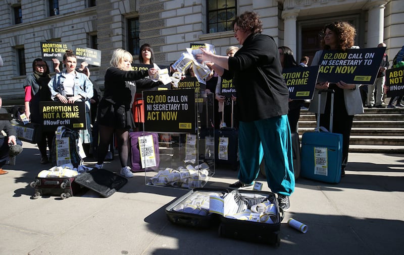 Derry Girls cast members Siobhan McSweeney (right) and Nicola Coughlan open suitcases outside the Treasury in Westminster to reveal the signatures on the petition demanding legislative change on Northern Ireland's strict abortion laws&nbsp;
