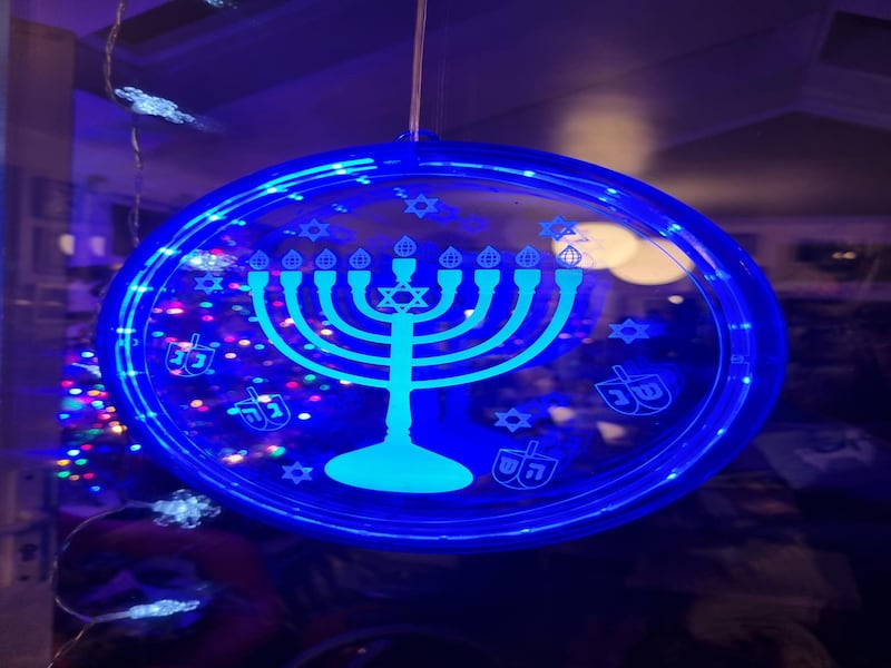 A symbol of the menorah with a Christmas tree in the backgroun