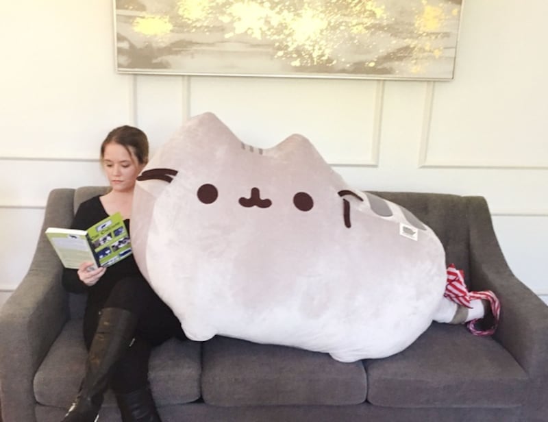 Megan poses with a giant toy cat that Bill Gates sent her