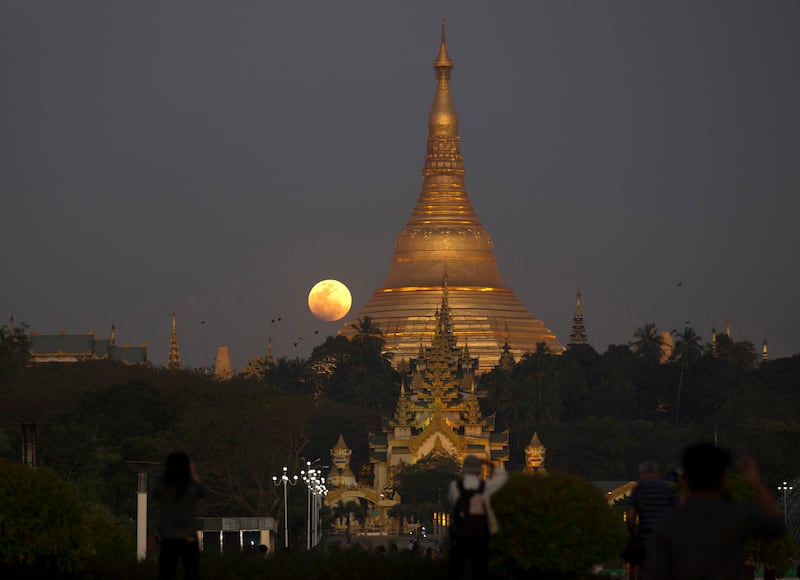 The moon rises behind Myanmar landmark Shwedagon pagoda