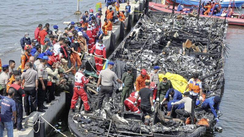 Rescuers search for victims from the wreckage of the ferry that caught fire off the coast of Jakarta after it was docked at Muara Angke Port. Picture by Rhana Ananda, Associated Press 