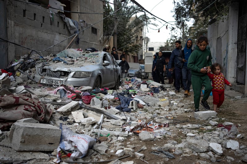 Palestinians look at the destruction after an Israeli airstrike in Rafah (AP Photo/Fatima Shbair)