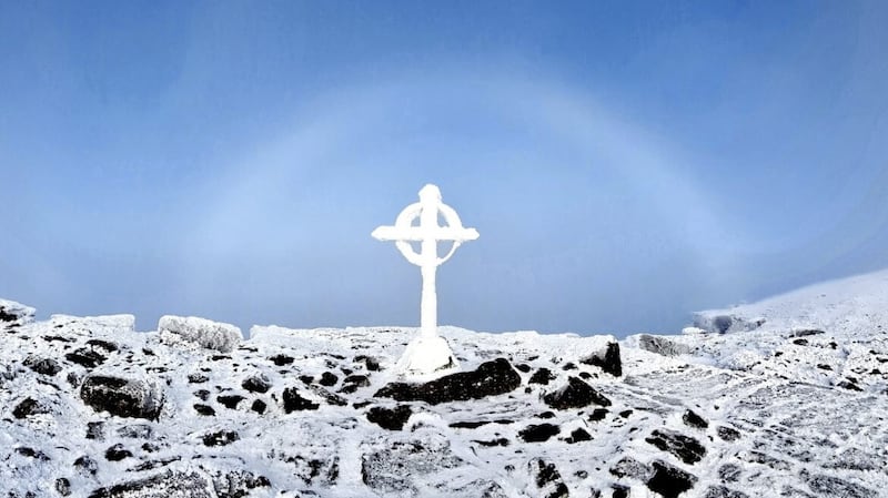A &#39;fogbow&rsquo; captured behind a cross on the Galtymore summit in Co Limerick on Saturday. A fogbow is like a rainbow but is white and forms when there&rsquo;s fog instead of rain. Picture: Emily Gleeson, Met &eacute;ireann 