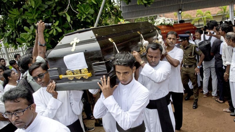 Clergymen carry coffins for burial during a funeral service for Easter Sunday bomb blast victims at St Sebastian Church in Negombo, Sri Lanka, on Tuesday. Picture by Gemunu Amarasinghe/AP 