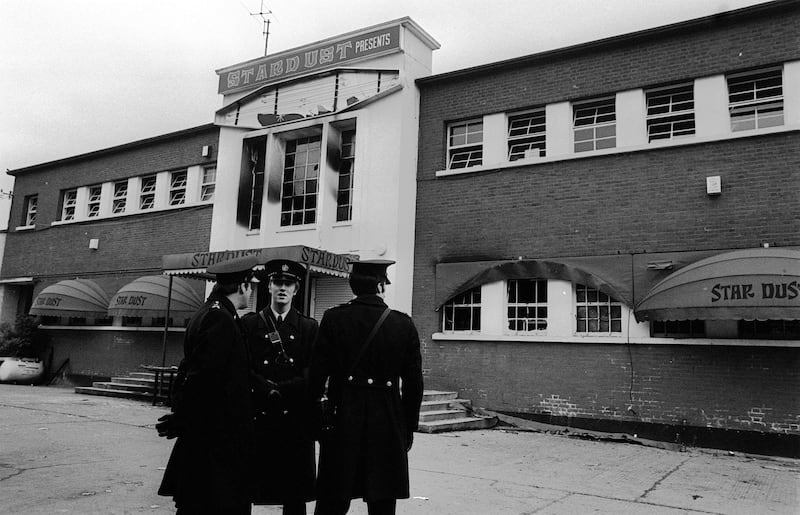 Police stand outside the main entrance of a fire-blackened Stardust Disco in Artane, Dublin, in 1981
