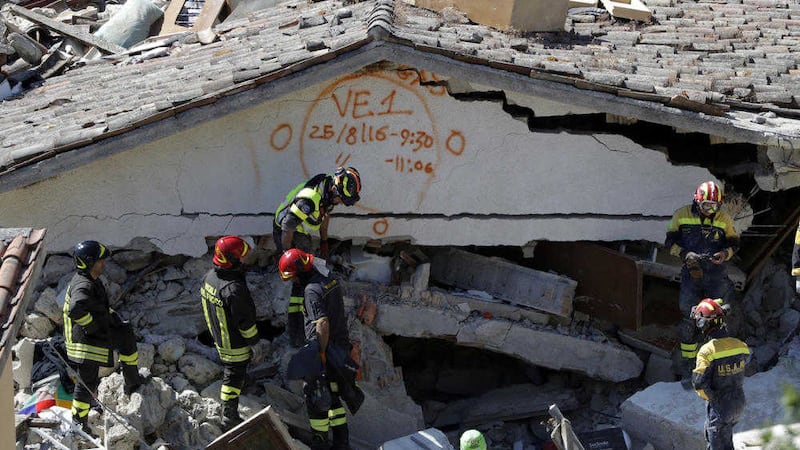 Rescuers mark a building with paint following the recent earthquake in Pescara Del Tronto, Italy. Picture by Gregorio Borgia, Associated Press