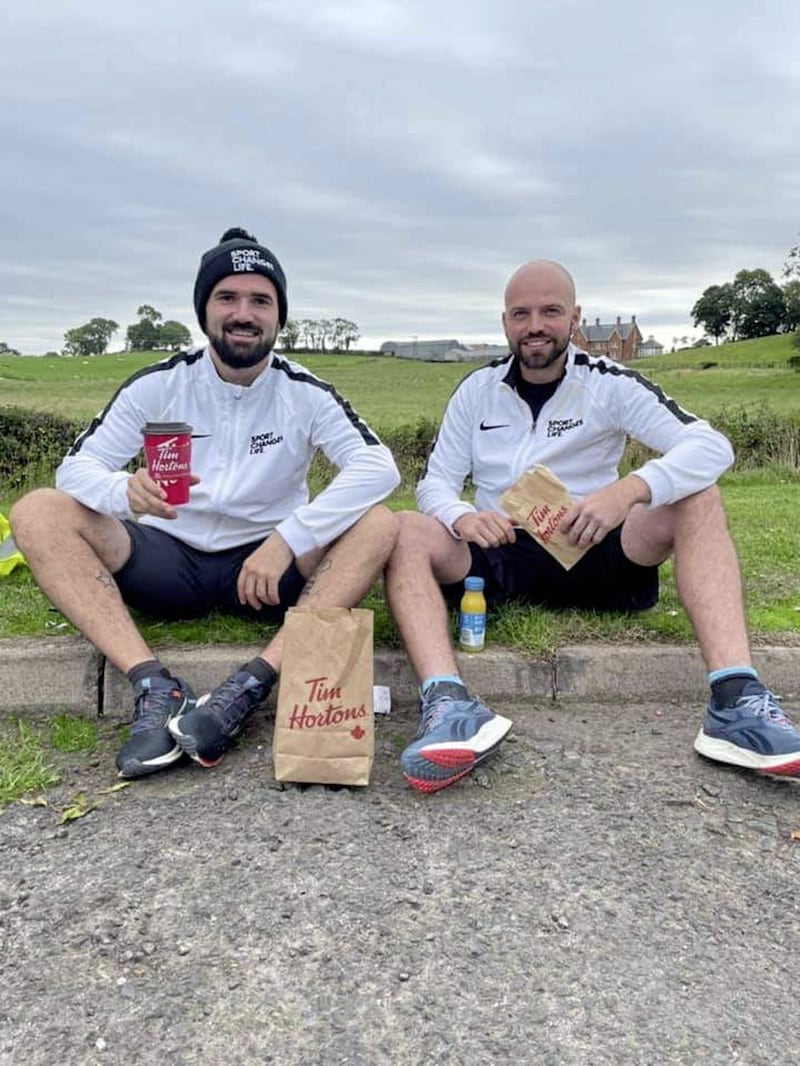 Gareth Brown, pictured left, and Chris Kirk take a well-earned kerb-side break during their Stride the Stadia fundraising quest for Sport Changes Life 