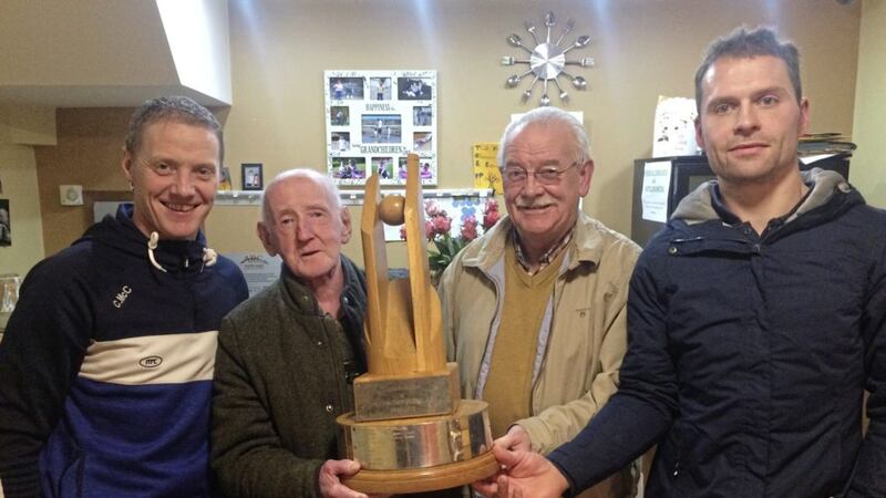 Dromore senior football manager Colm McCullagh and team captain Eoin McCusker present the Brendan Dolan Memorial Tyrone Division One League trophy to club stalwarts John McCusker and Michael Montague 