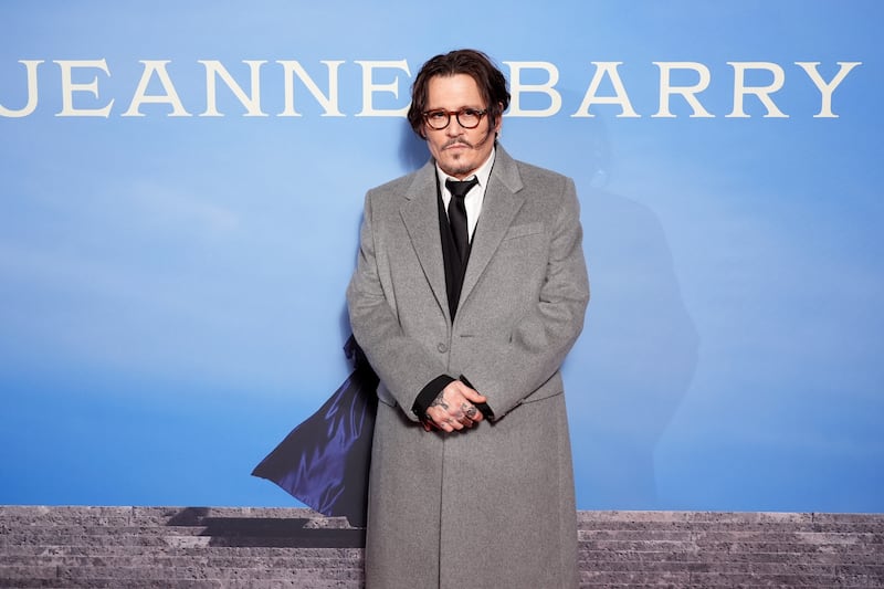Johnny Depp wore a grey coat over a black suit to the premiere