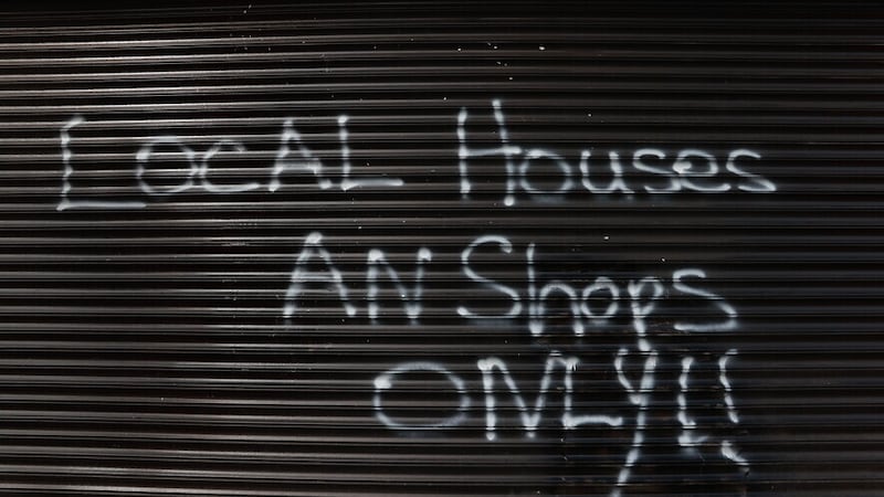 Racist graffiti scrawled on a shop shutter in south Belfast. Picture: Liam McBurney/PA
