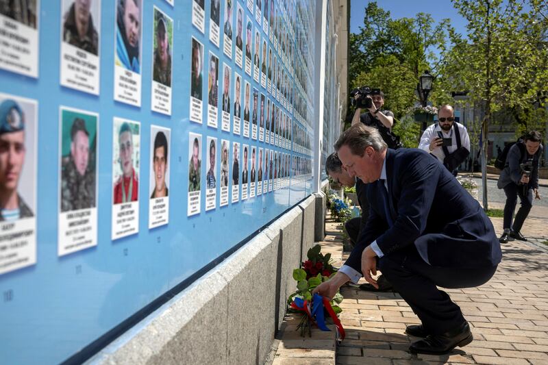 Lord Cameron laid flowers at a memorial wall to fallen servicemen outside St Michael’s Golden-Domed Monastery in Kyiv (Thomas Peter/Pool via AP)