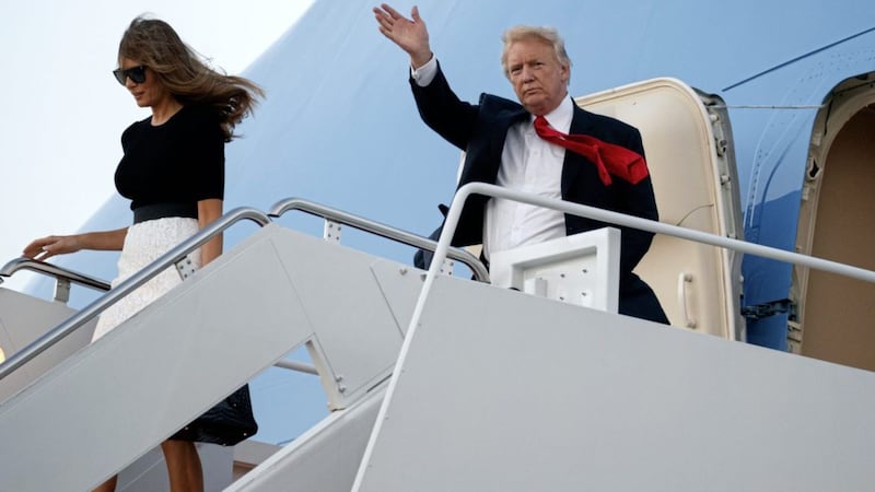 US president Donald Trump waves as he and first lady Melania Trump arrive back in the US following the G20 summit in Germany Evan Vucci/AP 