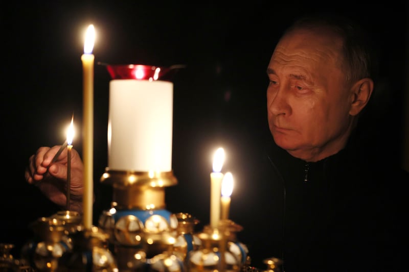 Russian President Vladimir Putin lights a candle to commemorate victims of an attack on the Crocus City Hall concert venue (Mikhail Metzel, Sputnik, Kremlin Pool Photo via AP)