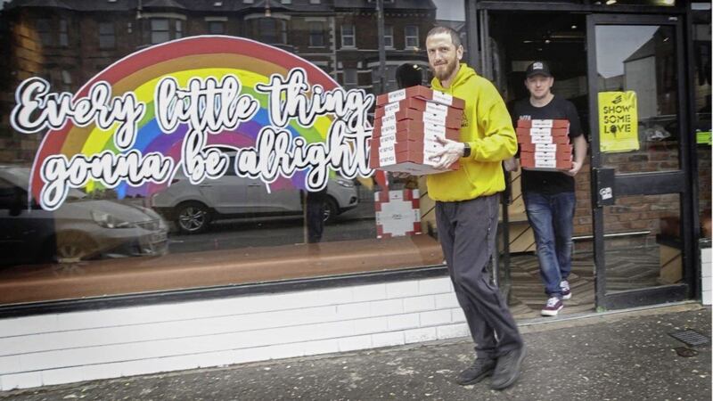 Last orders at Pizza Works as Eoin Scollay and Aodhan Braniff make a last delivery to Belfast hospital staff before pulling down the shutters. Picture by Hugh Russell 