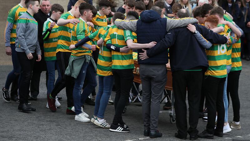 Edendork GAC players huddle around the coffin of Connor Currie outside St Malachy's Church. Picture by Brian Lawless, Press Association