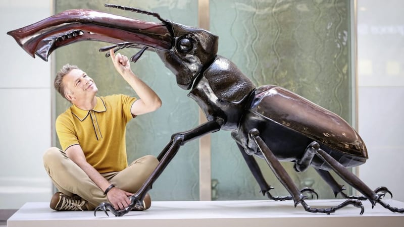 Chris Packham and a sculpture of a stag beetle 