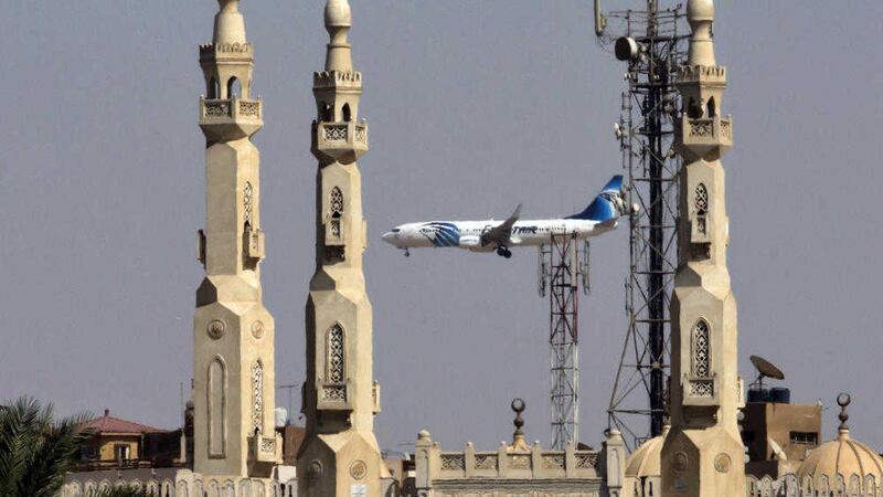An EgyptAir plane flies past minarets of a mosque as it approaches Cairo International Airport on Saturday. Picture: Amr Nabil/AP)