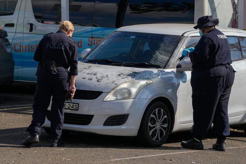 Police forensic officers inspect a car outside the Christ the Good Shepherd Church after the knife attack (Mark Baker/AP)