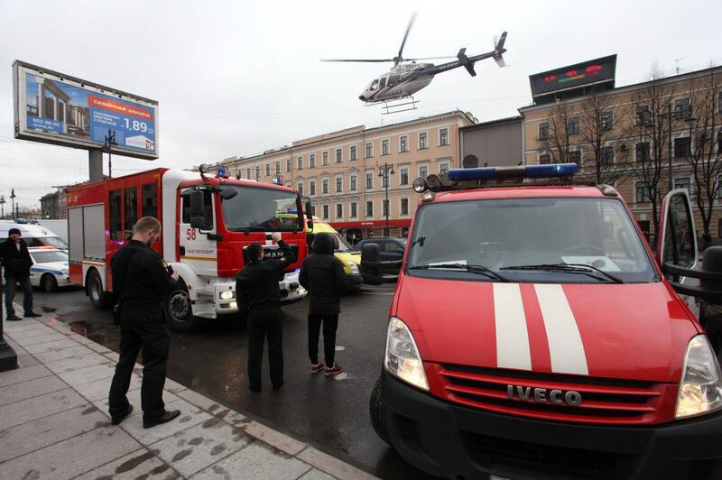 A helicopter flies over the fire trucks (Alexander Tarasenkov/AP)
