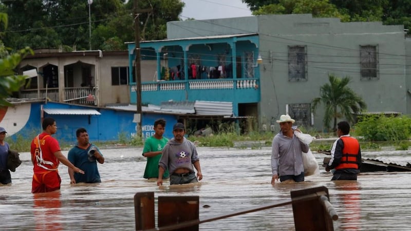 Men wade through a street flooded after the passing of Hurricane Iota in La Lima, Honduras, on November<br />18 2020. Picture by Delmer Martinez, AP