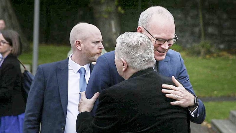 Irish Foreign Affairs Minister Simon Coveney is greeted by Fr Gary Donegan as he visits Belfast  on Wednesday to finish a speech which was disrupted by a loyalist attack earlier this year. Picture by Hugh Russell. 