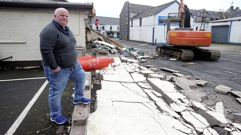 Walter Miller examines the damage to his shop in Ahoghill, Co Antrim, after an ATM was ripped from the wall. Picture by Mal McCann 