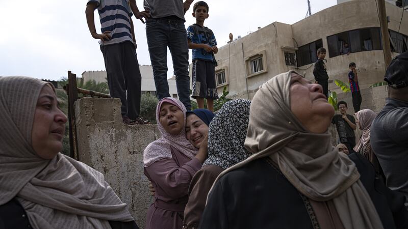 Relatives mourn people killed in an Israeli air strike in Gaza City on Monday (Fatima Shbair/AP/PA)