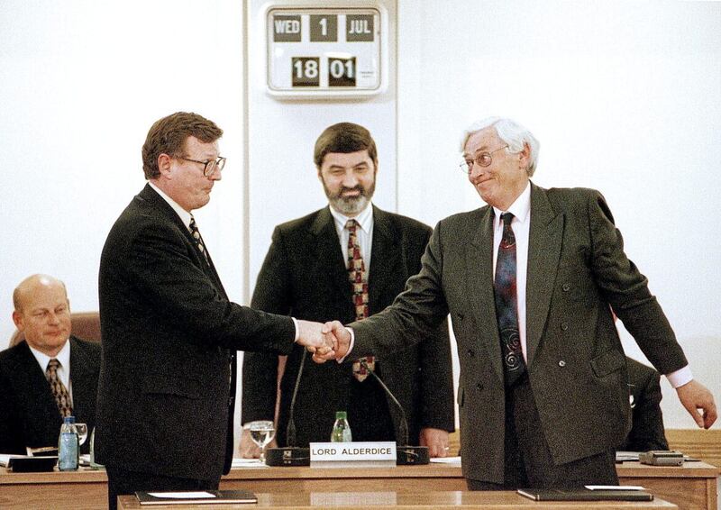 David Trimble and Seamus Mallon shake hands after being elected First and Deputy First Ministers of a new power-sharing government following the signing of the Good Friday Agreement in 1998, with Assembly Speaker Lord Alderdice looking on 
