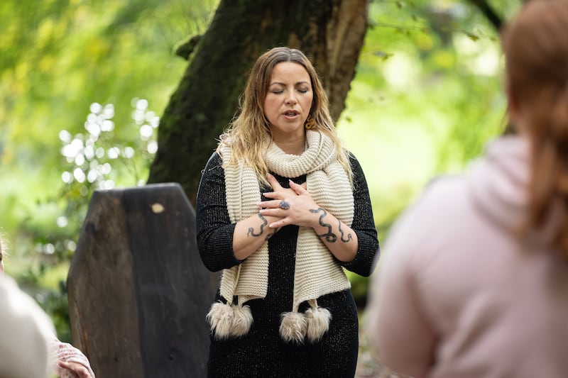Charlotte Church standing in front of the choir wearing a black dress and a white scarf
