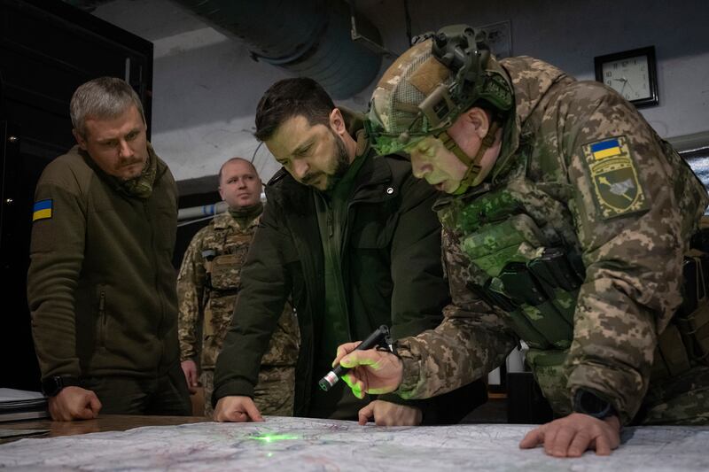Ukrainian President Volodymyr Zelensky, middle, looks at a map during a visit to the frontline city of Kupiansk, Kharkiv region, Ukraine, on November 30 (Efrem Lukatsky/AP)