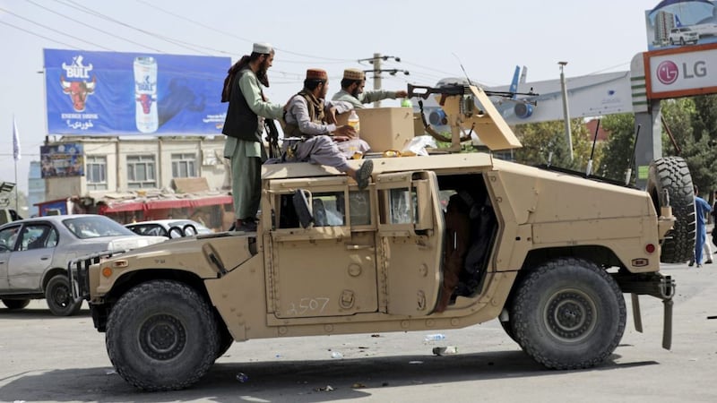 Taliban fighters stand guard in front of the Hamid Karzai International Airport, in Kabul (AP Photo/Rahmat Gul). 
