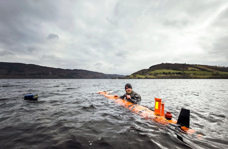 An engineer helps launch a search vessel at Loch Ness