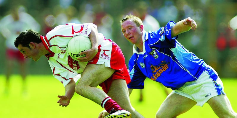 Tyrone's Davy Harte clears his lines under pressure from Cavan's Jason O'Reilly during the Ulster Senior Football Champiopnship semi-final in Clones on June 19 2005