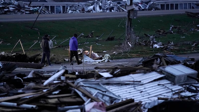 People walk through debris from severe storms in Lakeview, Ohio (Joshua A Bickel/AP)