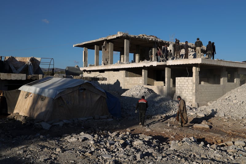 People work on a house damaged in the quake a year ago (Omar Albam/AP)