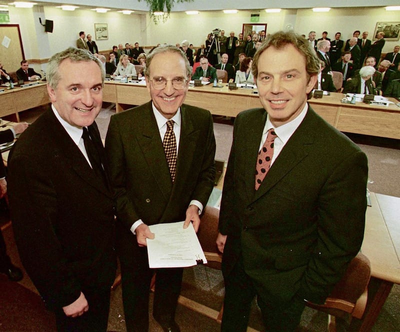 Bertie Ahern, George Mitchell and Tony Blair smiling after they signed the Good Friday Agreement in 1998.  