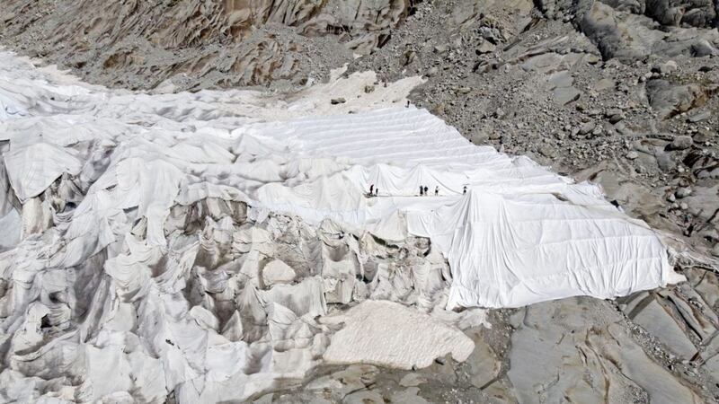 People cover the Rhone Glacier in blankets at the glacial lake above Gletsch near the Furkapass in Switzerland on Wednesday July 24 2019. Picture: Peter Klaunzer//AP 