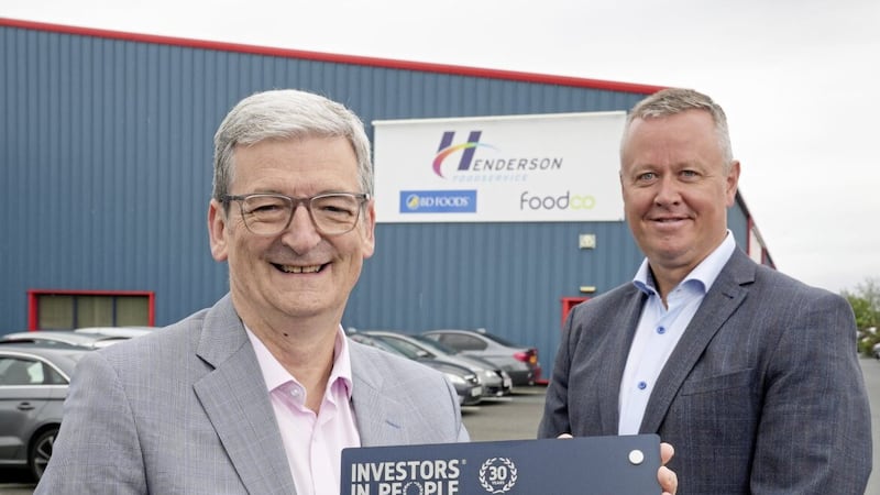 Henderson Group human resources director Sam Davidson and Henderson Foodservice director Cathal Geoghegan receive the Investors in People Gold accreditation plaque at the company&rsquo;s Mallusk headquarters 