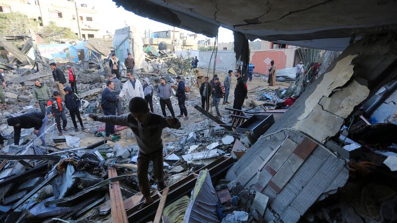Palestinians stand by a building destroyed in an Israeli bombardment in Rafah in the Gaza Strip (Hatem Ali/AP/PA)