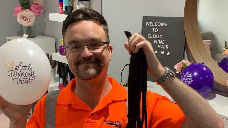 Stuart Hughes, who works for Network Rail in Birmingham, with the 10 18-inch ponytails he grew to make wigs for young cancer patients (Network Rail/PA)