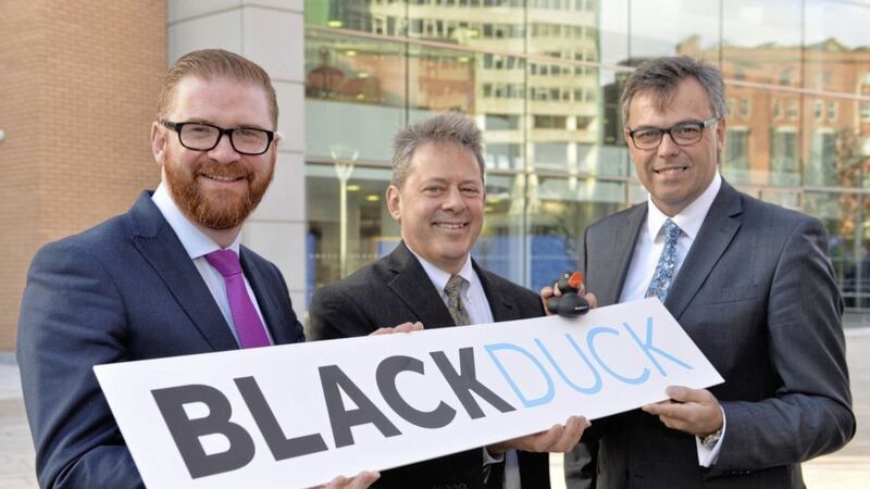 Black Duck Software president and chief executive Lou Shipley announces the company&#39;s new office in Belfast when he visited in October last year. With him are then-Economy Minister Simon Hamilton and Invest NI head Alastair Hamilton 