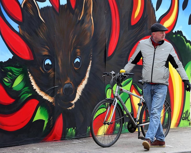 Pedro Donald, owner of the Sunflower Bar looks at the Hit the North artwork around the Union Street and Kent Street area in 2022