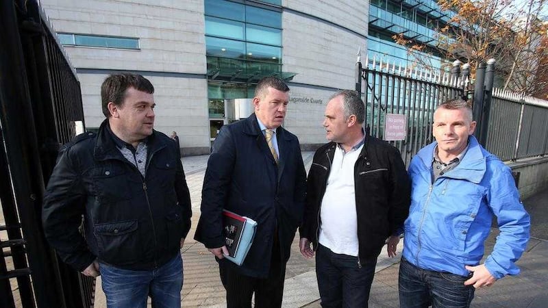 Damien Duffy, solicitor Niall Murphy, Paul Duffy and Shane Duffy outside Laganside Courts in Belfast after charges against them were dropped. Picture by Mal McCann. 