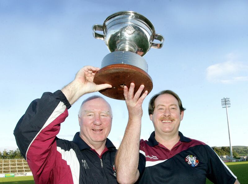 Sean McGoldrick and Sean McLaughlin raise the John McLaughlin Cup. They won two Derry senior championships as manager, in 2010 and 2018. Picture: Margaret McLaughlin