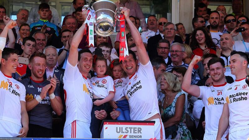 Sean and Colm Cavanagh lift the Anglo-Celt Cup, with Sean's daughters Eva and Clara